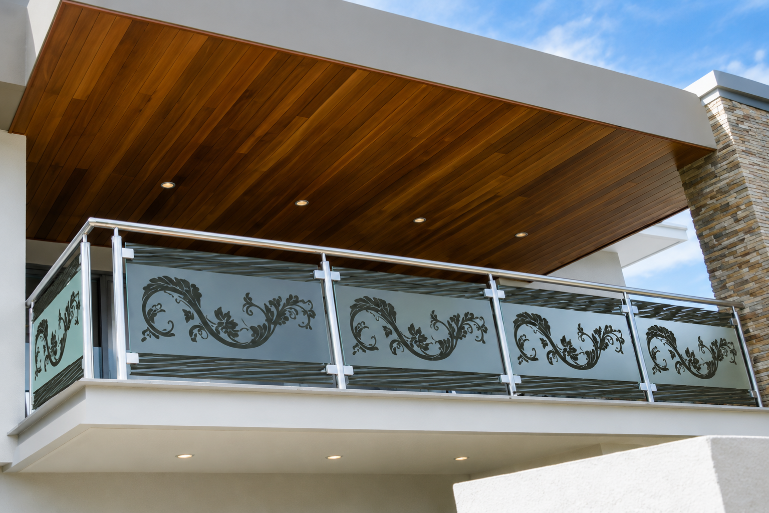 Balcony with steel-and-glass railing featuring floral-etched decorative infill panels