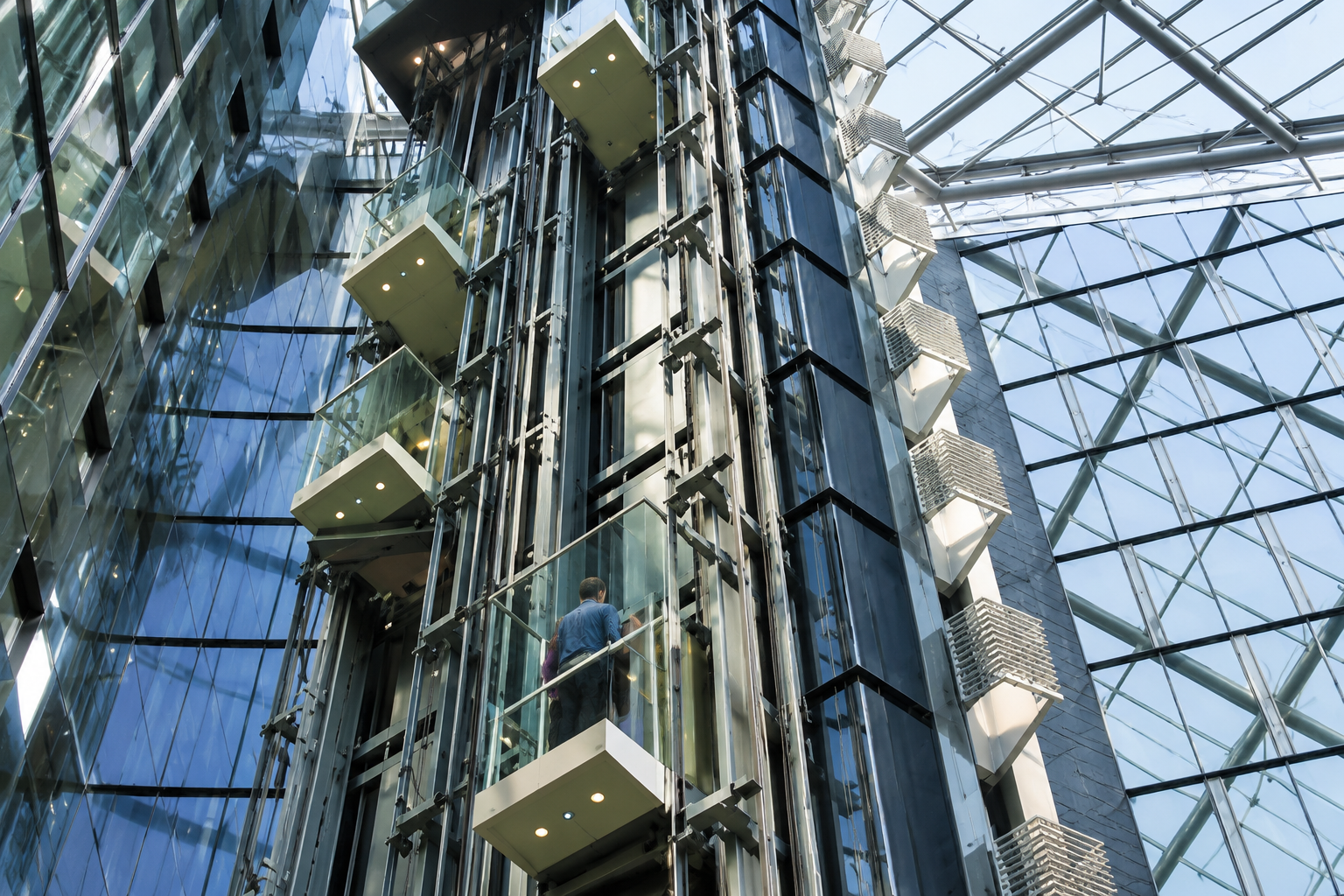 Illuminated glass atrium with panoramic elevator shafts